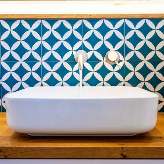 white ceramic bathtub with blue and white wall tiles